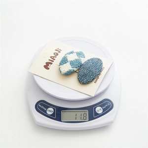 Détail de pinces à cheveux en tissu bleu sur une balance pesant 11,8g pour filles