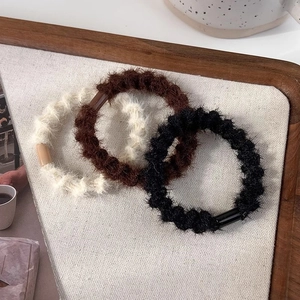 Détails de trois chouchous en peluche en blanc, marron et noir pour cheveux de femmes