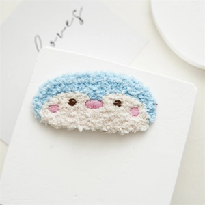 Detailed macro view of cute penguin towel embroidery hair clip with blue fluffy textures