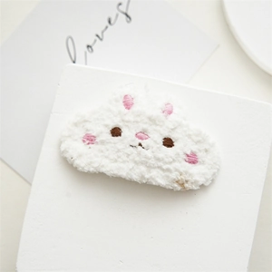 Detailed shot of cute white plush bunny hair clip with soft lamb wool texture and pink ears