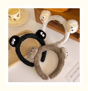 Gros plan de bandeaux en peluche mignons avec des boules de suie aux grands yeux colorés