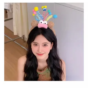 Detail showing colorful plush monster headband with spiral antennas and googly eyes decoration