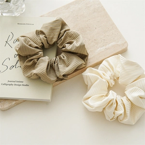 Close-up of ribbed texture hair scrunchies in light brown and cream white colors