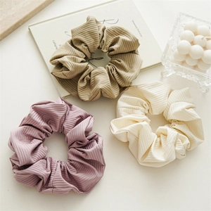 Detailed texture of high-elastic scrunchies in purple, khaki and beige ribbed fabric