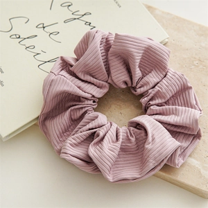 Close-up of elegant pink textured nylon scrunchie on a decorative stone surface
