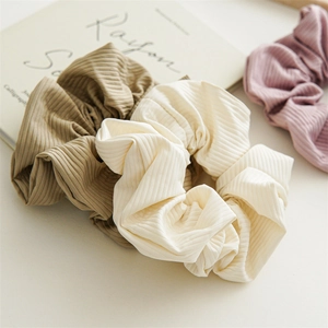 Elegant nylon scrunchies in cream and khaki with vertical ribbed texture for hair styling