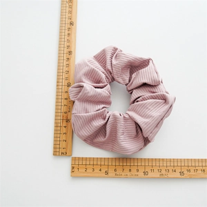 Pink knit scrunchie with vertical ribbed texture and 10cm diameter for hair styling