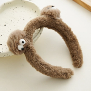Vue détaillée du serre-tête monstre en peluche marron avec fourrure douce et yeux ronds