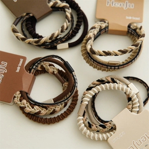 Detail of coffee-colored elastic hair ties with woven and leopard patterns on cardboard