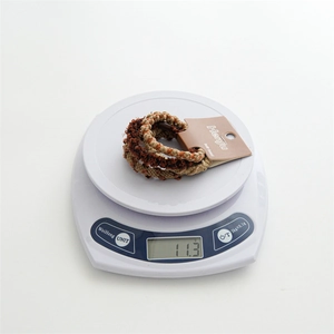 Close-up of brown braided elastic hair ties set on a scale weighing 11.3 grams