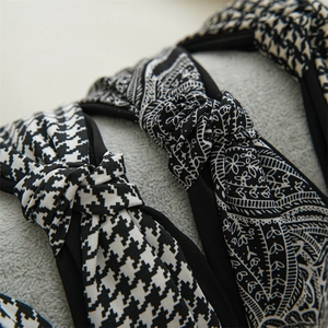 Detailed view of the houndstooth and paisley patterned fabric on the knotted headband