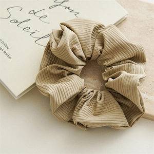 Macro shot of elegant beige nylon scrunchie showing detailed ribbed fabric texture