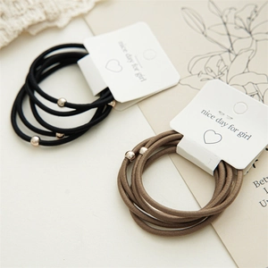 Detailed close-up of elastic hair bands with polished rose gold beads in black and brown