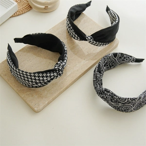 Elegant houndstooth and paisley knotted headbands set on a stylish marble tray