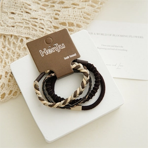 Detail showing a coffee-colored hair tie set with braided and leopard print textures