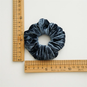 Chouchou en velours bleu foncé avec plis élastiques et mesure du diamètre de 8,5 cm