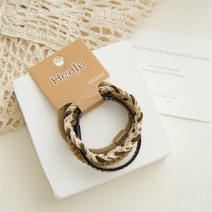 Detailed view of coffee-colored braided hair ties set on a white platform with lace