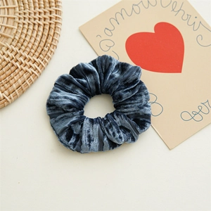 Détail du chouchou en velours bleu montrant la texture plissée et la grande élasticité