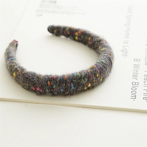 Détail du serre-tête en tricot gris épais avec des taches colorées pour l'automne
