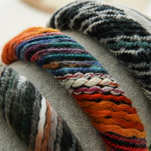 Close-up detail of knitted textures in rainbow, earth, and monochrome yarn headbands