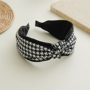 Detailed view of the houndstooth pattern fabric and decorative knot on the headband