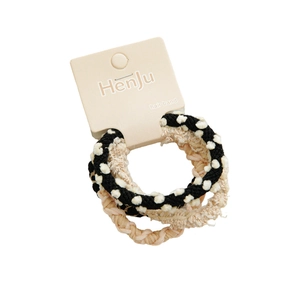 Brown braided hair bands set with polka dot and pleated patterns on display card