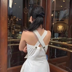 Close-up of heart-shaped button detail on the back of an elegant white backless dress
