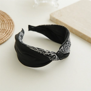 Detail of wide knotted headband with black and white ethnic paisley print on silk fabric
