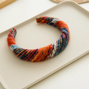 Detailed macro view showing mixed colored knitted wool texture and woven headband surface