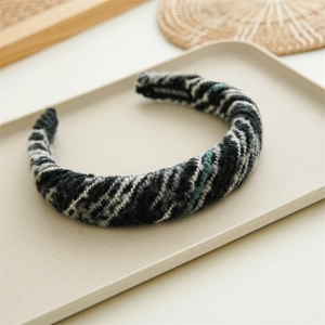 Close-up of black and white knitted headband detail with handmade label on inner side