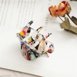 Detail der 5,5 cm Acetat-Haarklammer mit buntem Marmormuster auf Vintage-Buch