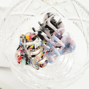 Nahaufnahme stilvoller 5,5 cm Acetat-Haarklammern mit Marmor-Textur in einer Glasschale