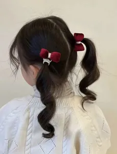 Detalle de gomas de pelo con lazo de terciopelo rojo para peinados infantiles