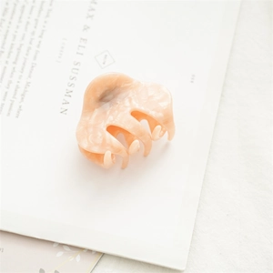 Detailaufnahme der 5,5 cm kleinen Haarklammer aus Acetat in cremiger orangefarbener Marmoroptik
