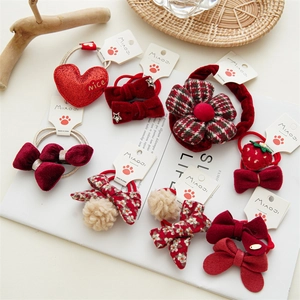 Detalle de coleteros rojos con lazos, corazones de terciopelo y flores para niñas