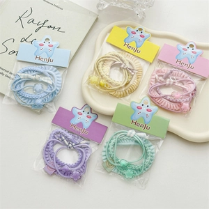 Detailed view of 5-piece candy color hair ties set with cute floral charms in packaging