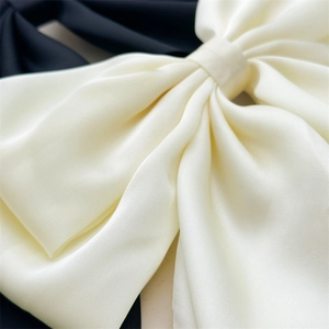 Eleganti fermagli per capelli con fiocchi oversize in raso crema e nero con nastri setosi