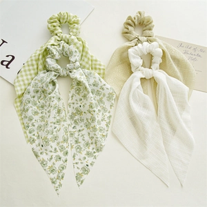 Flat lay set of four floral and plaid pattern hair scrunchies with long ribbons