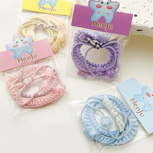 Detail of candy-colored hair tie sets featuring heart and flower charms in pastel tones