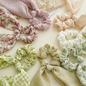 Detail of floral and plaid bunny ear scrunchies in pastel pink and green cotton fabric
