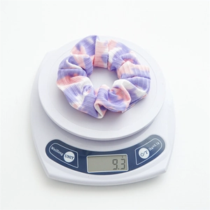 Lightweight striped knit scrunchie in purple and pink displayed on a digital scale