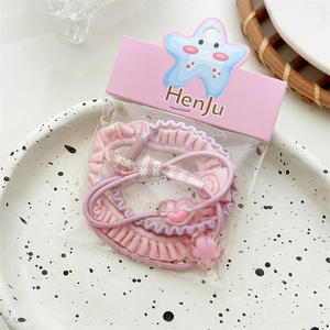 Detailed view of pink and purple elastic hair scrunchies set with floral charms