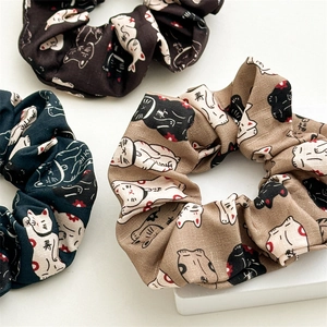 Texture détaillée de chouchous en tissu avec motifs de chat porte-bonheur en trois couleurs