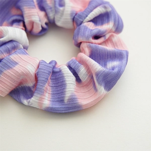 Close-up of pink and purple tie-dye ribbed fabric scrunchie with elastic texture
