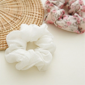 Dettaglio di elastico bianco a scacchi con paillettes e elastico floreale rosa su stuoia