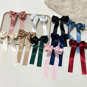 Detail of silk satin bow hair clips with long ribbons in multiple elegant colors