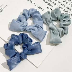 Three-piece set of satin scrunchies with bow design in shades of blue and navy