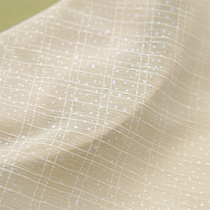 Macro detail of breathable beige fabric with sparkling iridescent dots and mesh texture