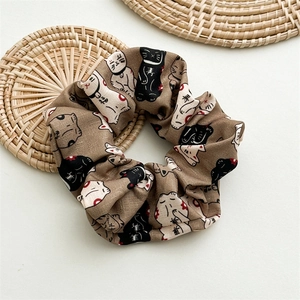 Détail du chouchou en tissu avec imprimé chat porte-bonheur et caractères sur coton beige