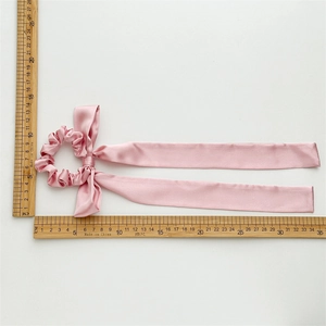 Pink ribbon bow scrunchie with smooth satin texture and 35cm long streamers